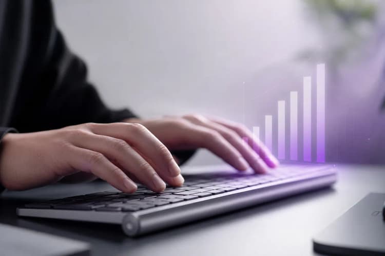 Mãos digitando em um teclado de computador com um gráfico de barras roxo sutil aparecendo ao lado.