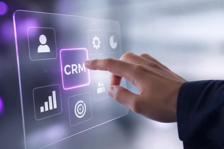 Uma mão escolhendo entre várias opções de ícones de software em uma tela transparente com detalhes em roxo, representando a seleção de um CRM.